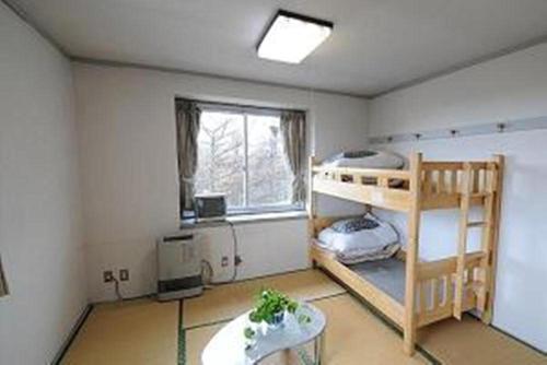 草津草津高原青年旅舍的客房设有两张双层床和一扇窗户。