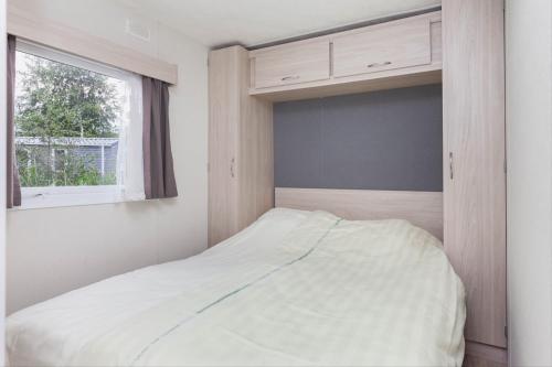 HoekMB Zeeuwse Mobile Home的一间卧室设有一张床和一个窗口