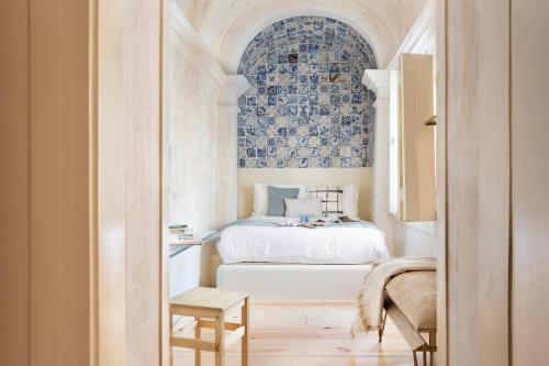里斯本Archi-Pelago Alfama Design Suites Guesthouse的一间卧室配有一张蓝色和白色墙壁的床