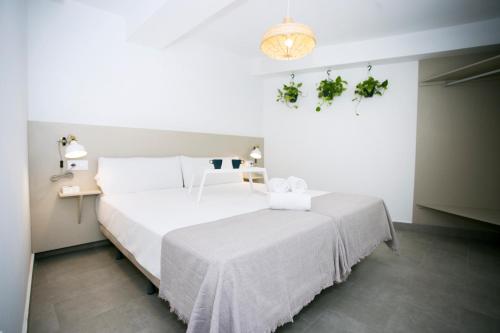 多列毛利诺斯MONKÓ - COCO & TROPYCAL APARTMENT o的卧室配有白色床单和白色大床