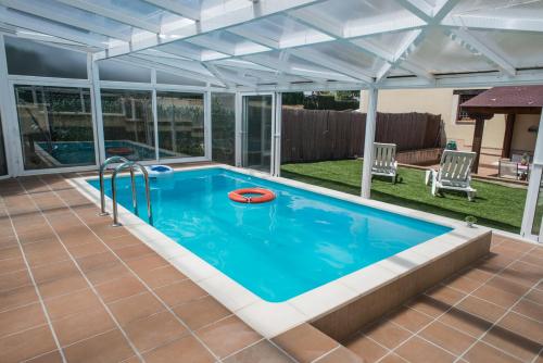 Palazuelos de EresmaCasa Robledo的一个带凉棚的游泳池和一个室外游泳池