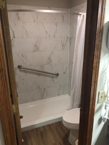 Friona菲瑞纳维旅馆的浴室配有白色浴缸和卫生间。