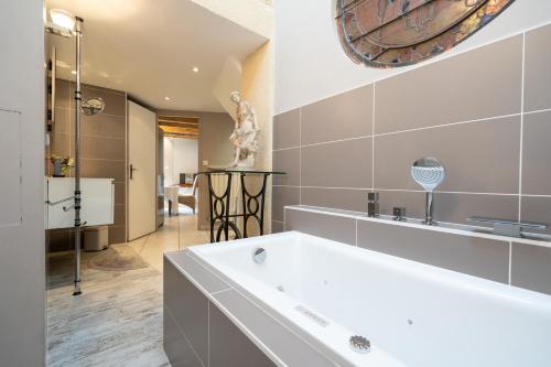 罗纳河畔的图尔农La maison de Raphaël的浴室配有白色浴缸和镜子