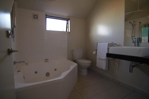 基督城瑞卡顿大都会汽车旅馆的带浴缸、卫生间和盥洗盆的浴室