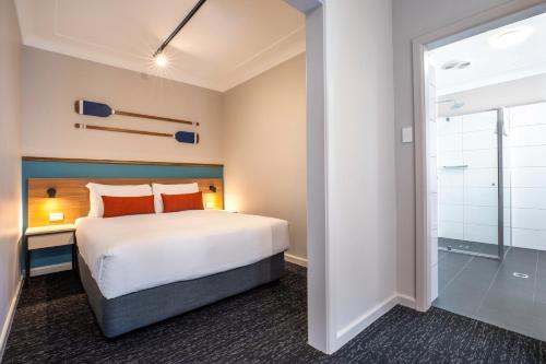 艾塔龙海滩Nightcap at Ocean Beach Hotel的酒店客房配有一张床和淋浴
