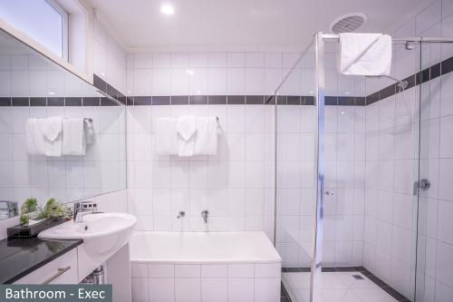 墨尔本Clocktower Apartment Hotel的白色的浴室设有水槽和淋浴。