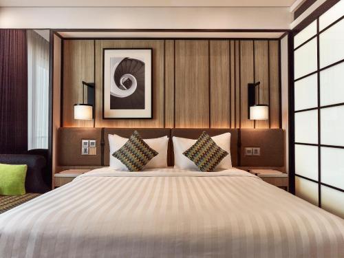 加拉旺光大大酒店 的一间卧室配有一张大床和两个枕头