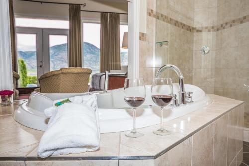 奥索尤斯设拉子别墅酒店的浴室水槽上放两杯葡萄酒