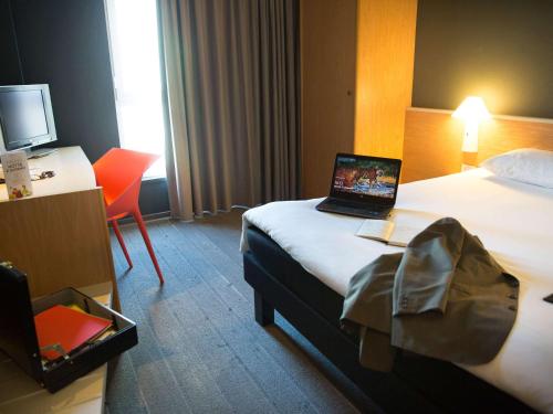 塞斯托-菲奥伦蒂诺宜必思佛罗伦萨机场北酒店的酒店客房,配有一张带笔记本电脑的床