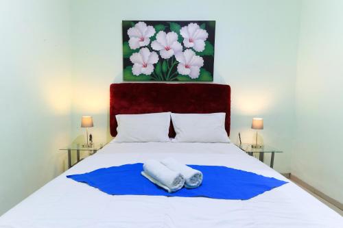 马卡萨Labuana Homestay & Cafe Garden的一间卧室配有一张床,上面有两条毛巾