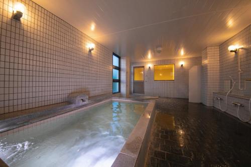 成田Narita AIC Airport Hotel的带浴缸的浴室内的大型游泳池