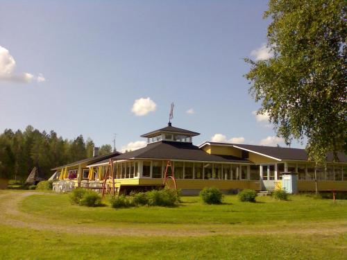 SukevaLohirannan lomakylä的一座黄色的大建筑,上面有一座塔