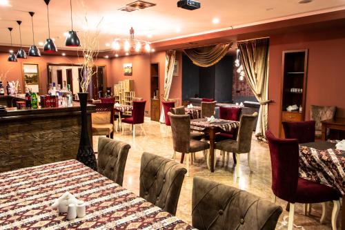 巴库Atropat Old City Hotel的一间带桌椅的餐厅和一间酒吧