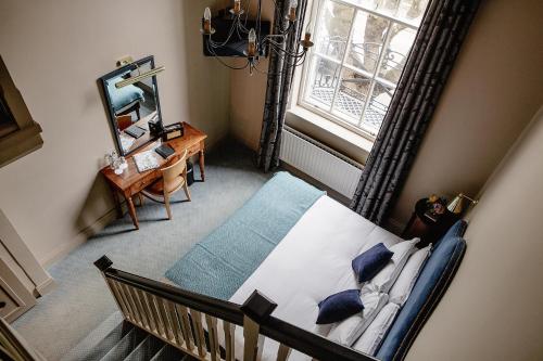 都柏林彭布罗克联排别墅酒店的一间卧室配有一张带蓝色枕头的床和一扇窗户。