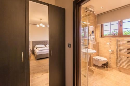 DumbrăveniPension Kokel的浴室设有玻璃门,可通往卧室