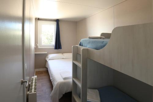 Sabaris巴约纳普拉亚野营酒店的一间小卧室,配有双层床和窗户