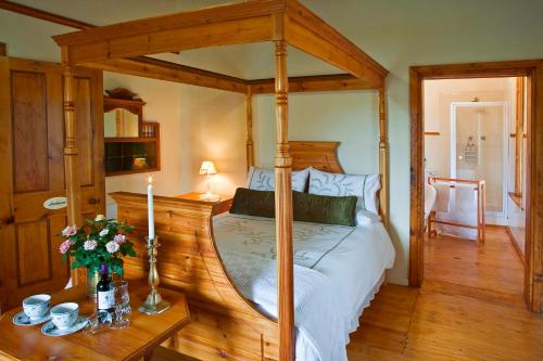 弗朗斯胡克威利之心旅馆的一间卧室设有一张天蓬床和木地板。
