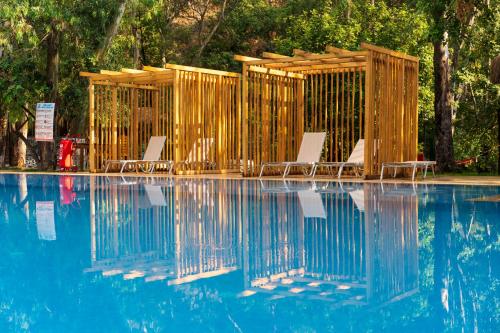 费特希耶Suna Village Hotel & Bungalow Fethiye的一组椅子坐在游泳池旁