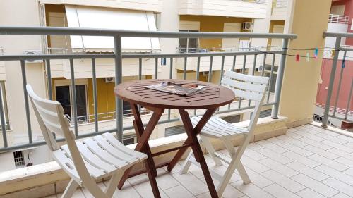 奥里库姆Bonbon Sea Apartment的阳台上配有一张木桌和两把椅子