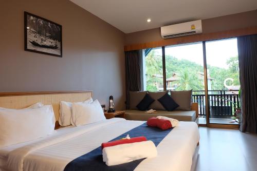 美翰Koh Ma Beach Resort - SHA Extra Plus的酒店客房,设有两张床和一张沙发