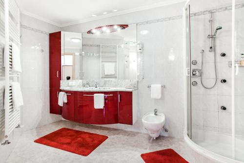 圣莱奥纳尔多因帕西里亚Das Bergland - Vital & Activity的一间带红色橱柜、淋浴和盥洗盆的浴室