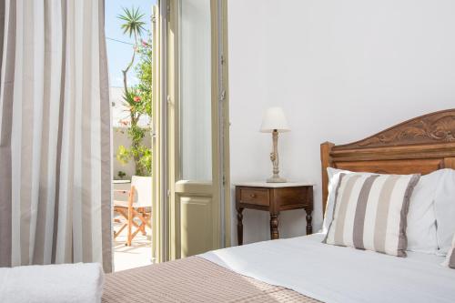 卡特瑞杜斯阿尔迪酒店的一间卧室设有一张床,一扇门通往庭院