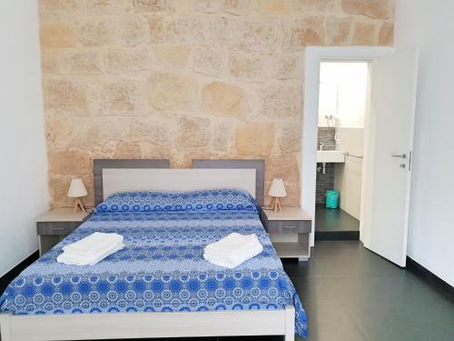 拉古萨码头Blu Maris Acqua的一间卧室配有床和两张带毛巾的桌子。