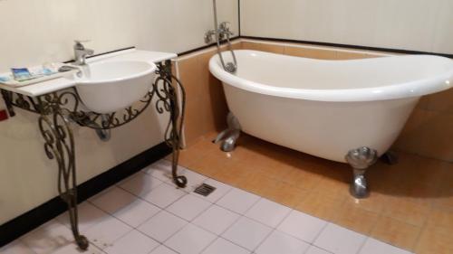 土城区雪瓈花园汽车旅馆的浴室设有浴缸和水槽。