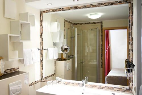 道恩Landhotel Krolik的浴室镜子配有水槽和淋浴