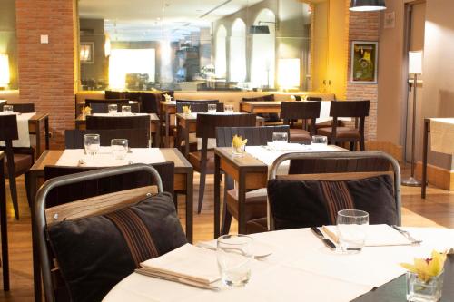 佛罗伦萨星际托斯卡纳酒店的餐厅设有木桌、椅子和白色的桌布
