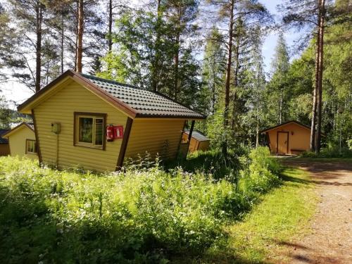 SukevaLohirannan lomakylä的森林中间的黄色小小屋