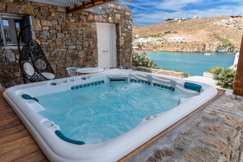 超级天堂海滩Etesians Suites & Villas的享有水景的天井内的热水浴池