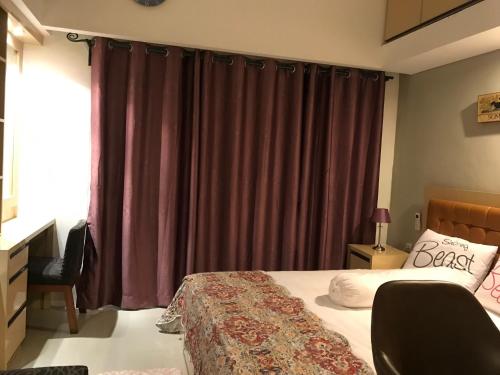 茂物Ruang Bravia Bogor Icon Hotel的一间卧室配有一张紫色窗帘的床