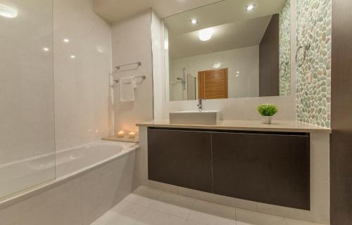卢斯B27 - LuzBay 2 Bed Apartment的带浴缸、水槽和镜子的浴室