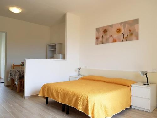 拉科纳Mini Appartamenti Elba的卧室配有一张床,墙上挂有绘画作品