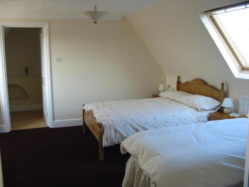 诺里奇Home farm cottage Guest House的一间卧室设有两张床和窗户。