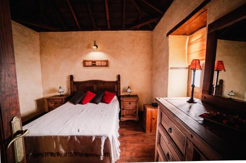 蒂哈拉费Casa Elena的一间卧室配有一张带红色枕头的床