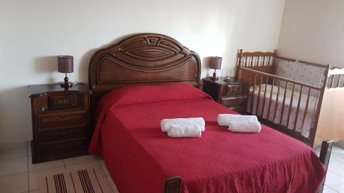 CalhetaAdega do Batista的一间卧室配有红色的床和2条毛巾