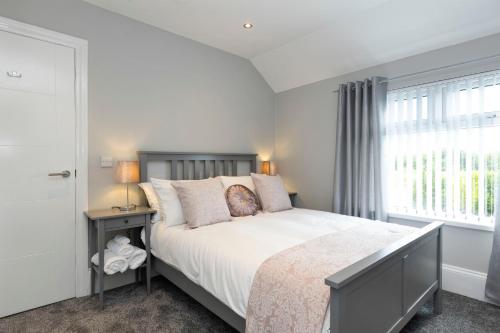 贝尔法斯特Chestnut House, Sleeps 11, Beautiful, spacious & comfortable的一间卧室设有一张大床和一个窗户。