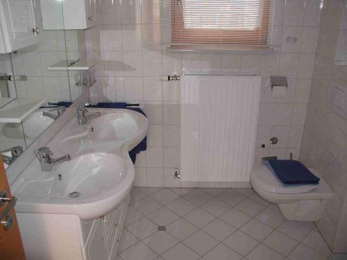 滨湖科伊查赫Landhaus Scherling的白色的浴室设有水槽和卫生间。