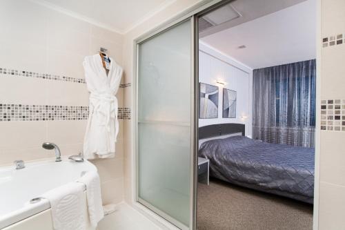 顿河畔罗斯托夫唐广场国会酒店 的带淋浴和盥洗盆的浴室以及1张床。