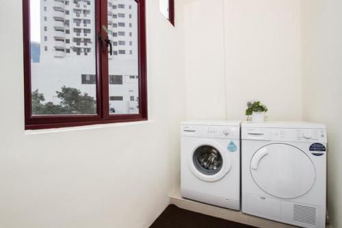新加坡Heritage Collection on Boat Quay - South Bridge Wing的洗衣房配有洗衣机和窗户