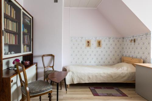 塔林蒂吉民宿的一间卧室配有一张床、一张桌子和一把椅子