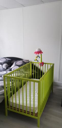 圣吉欧梅斯84 ėme rue的一张带床的房间里摆放着绿色婴儿床