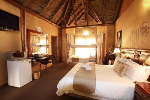 库鲁曼Kuruman Inn的酒店客房设有一张大床和一张书桌。