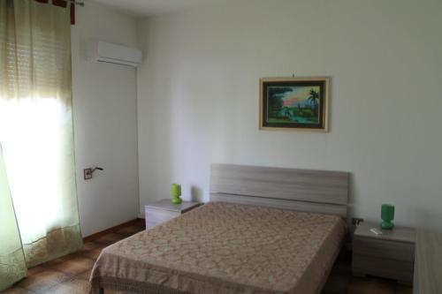 帕拉比塔Appartamento vacanza Salento的卧室配有一张床,墙上挂着一幅画