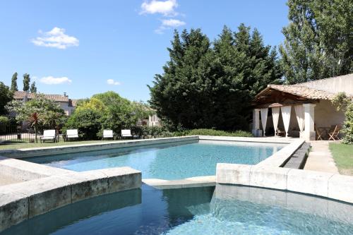 奥朗日尚布尔 d'HôtesJustin de Provence酒店的庭院内的游泳池,带椅子和树木