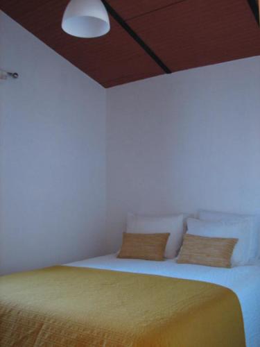 莫托拉Casa da Avó Mina的白色卧室配有一张黄色毯子床