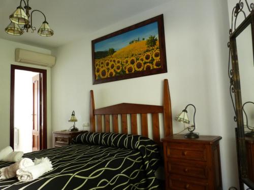 卡索拉Casa La Antigua Almazara的一间卧室配有一张床,并画着向日葵