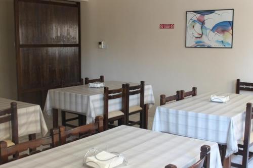 尼科西亚丹尼斯酒店的餐厅配有桌椅和白色桌布